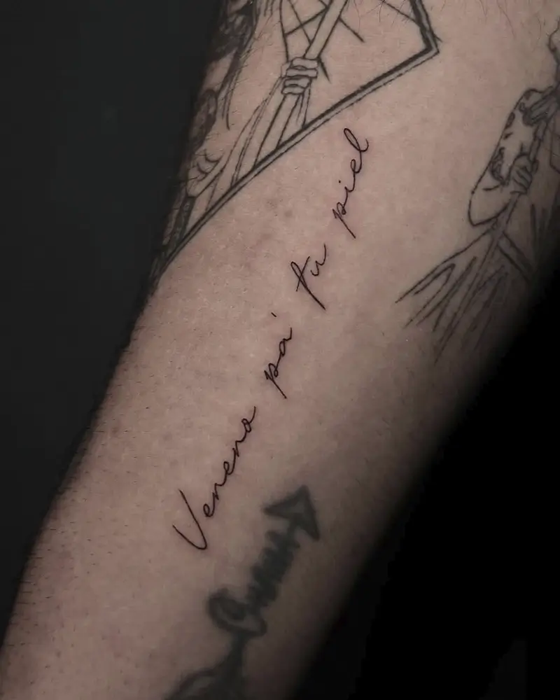 Frase en lettering de línea fina en el brazo, por Carmen González