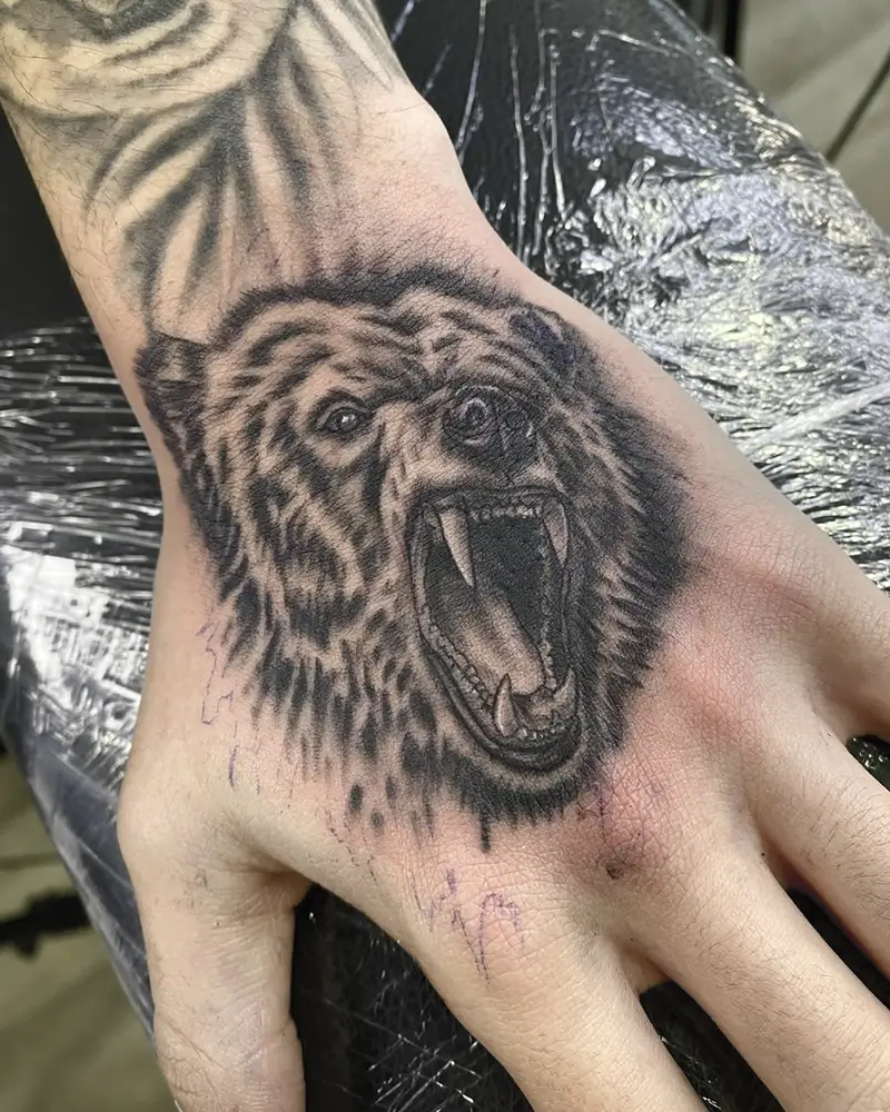 Tatuaje realista de un oso en el antebrazo, por Guti