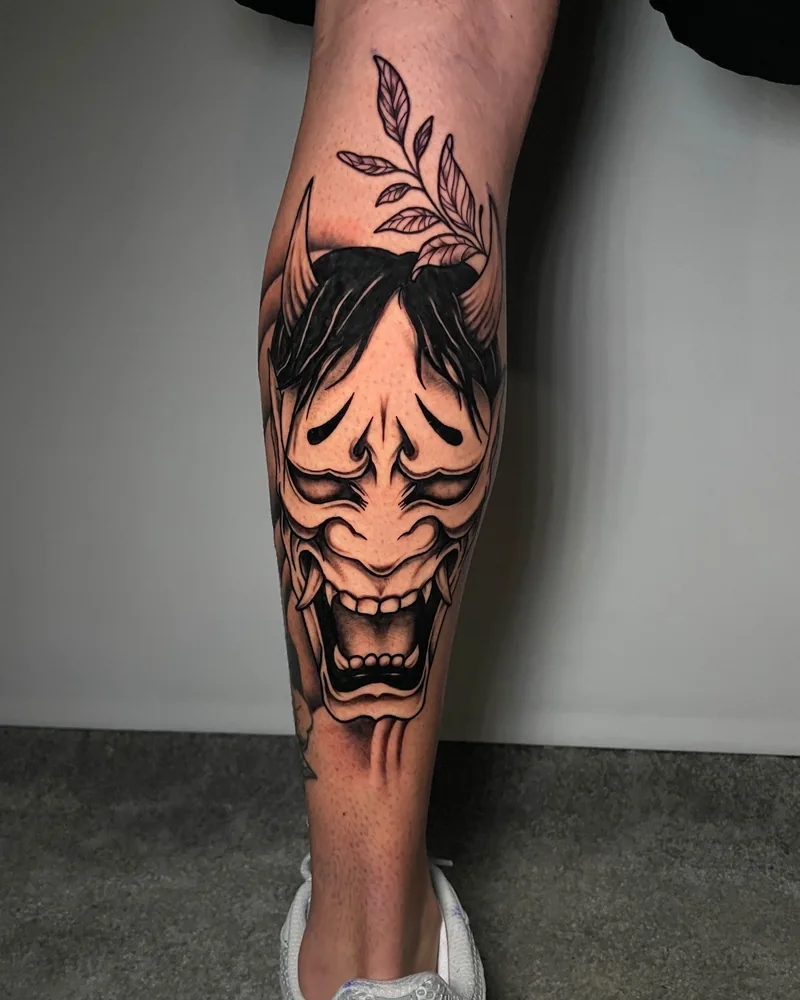 Tatuaje blackwork de una máscara Hannya japonesa en pierna, realizado por Guti en Yokai Tattoo Málaga