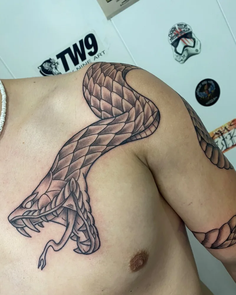 Tatuaje blackwork ornamental de una serpiente en pecho y hombro, realizado por Guti en Yokai Tattoo Málaga
